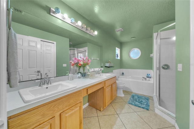 full bathroom with tile patterned floors, toilet, separate shower and tub, a textured ceiling, and vanity