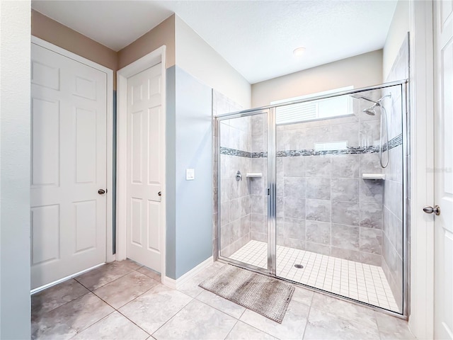 bathroom with tile patterned flooring and a shower with shower door