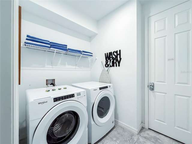 laundry room with washing machine and dryer and light tile patterned floors