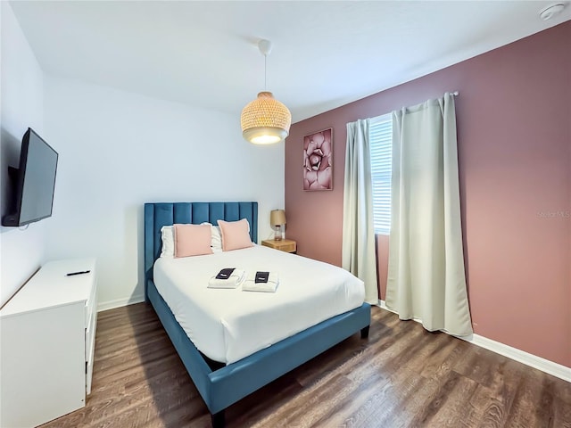 bedroom with dark hardwood / wood-style flooring