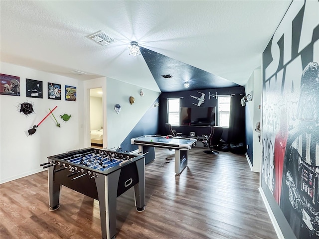 playroom with hardwood / wood-style flooring, vaulted ceiling, and a textured ceiling