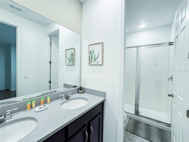 bathroom featuring a shower with door and vanity