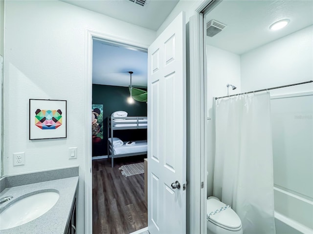 full bathroom featuring wood-type flooring, toilet, vanity, and shower / tub combo with curtain