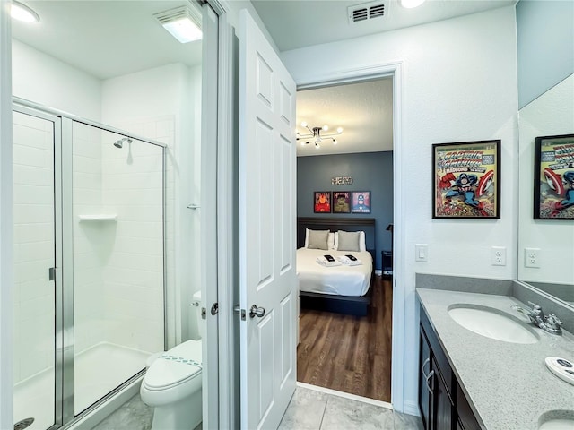 bathroom with hardwood / wood-style floors, toilet, an enclosed shower, and vanity