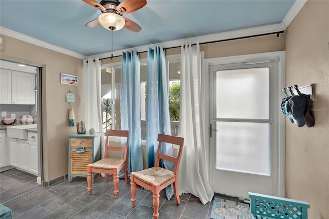 sitting room with ceiling fan and crown molding