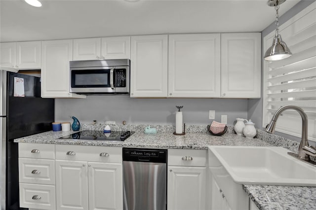 kitchen with sink, white cabinetry, decorative light fixtures, and appliances with stainless steel finishes