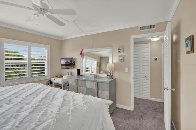 carpeted bedroom with a closet, ceiling fan, and crown molding