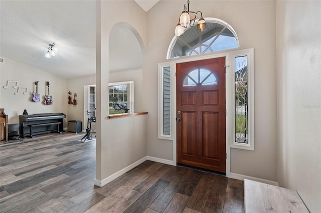 entryway with an inviting chandelier, dark hardwood / wood-style flooring, and lofted ceiling