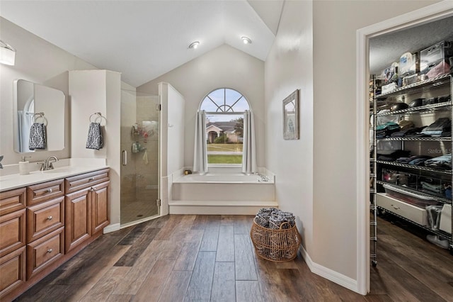 bathroom featuring separate shower and tub, lofted ceiling, and vanity