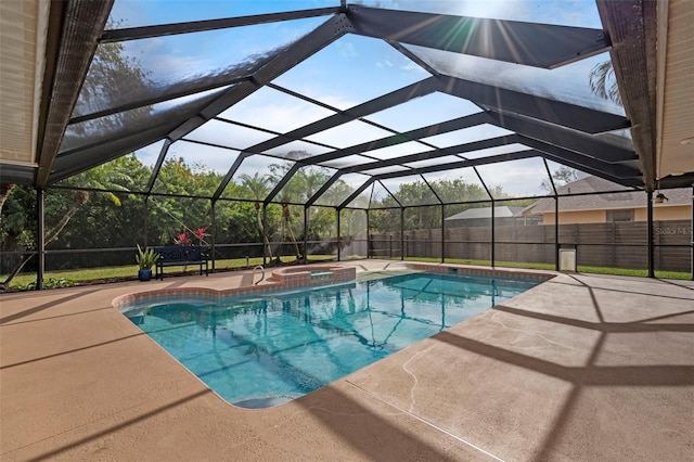 view of pool with glass enclosure, an in ground hot tub, and a patio