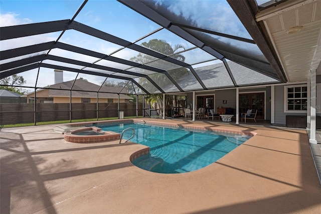 view of pool with glass enclosure, an in ground hot tub, and a patio