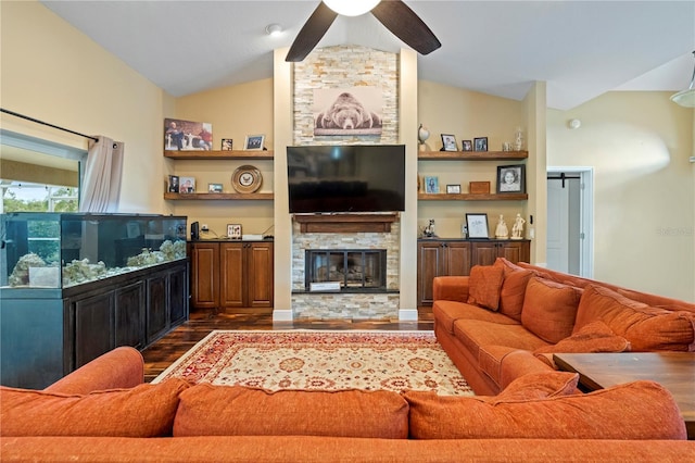 living room with a stone fireplace, built in shelves, ceiling fan, dark hardwood / wood-style floors, and lofted ceiling