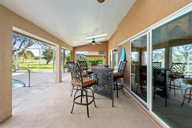 sunroom with ceiling fan and vaulted ceiling