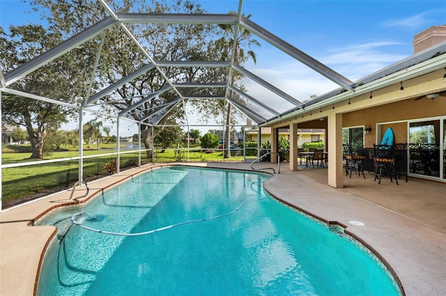 view of pool with glass enclosure and a patio