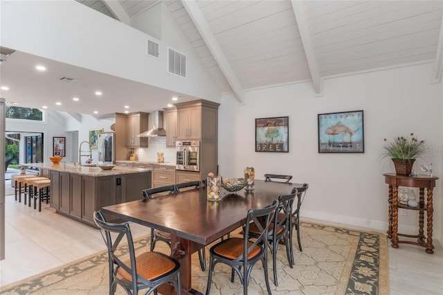 dining space with sink, high vaulted ceiling, and beamed ceiling