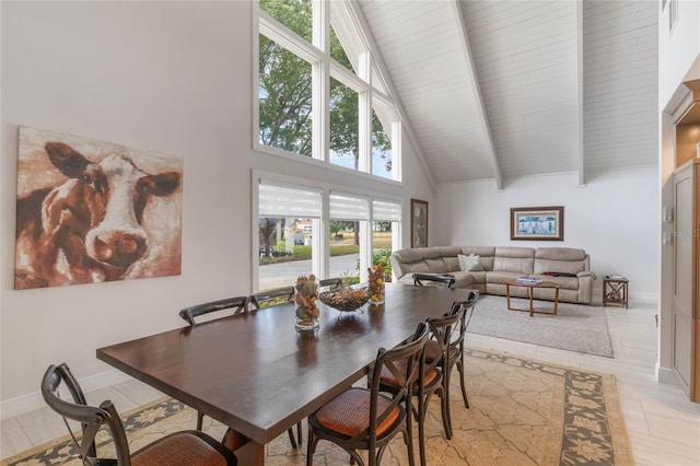 dining room with high vaulted ceiling and beamed ceiling