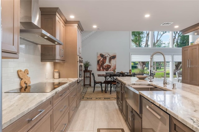 kitchen with tasteful backsplash, dishwasher, black electric stovetop, light stone countertops, and wall chimney range hood