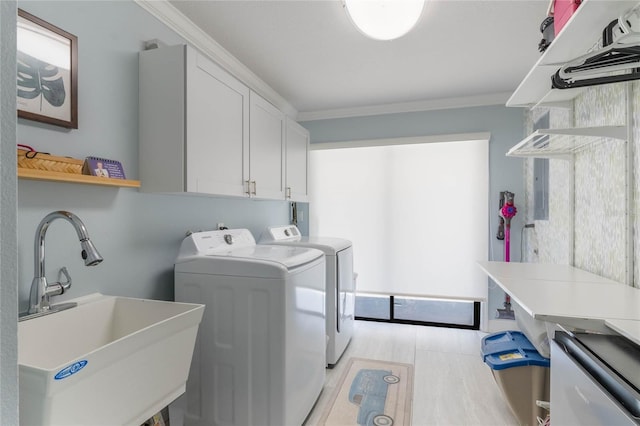 washroom featuring sink, cabinets, ornamental molding, washer and dryer, and light wood-type flooring