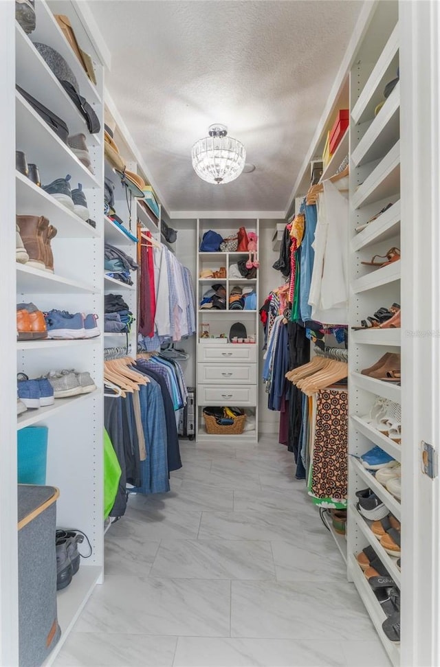 walk in closet featuring a chandelier