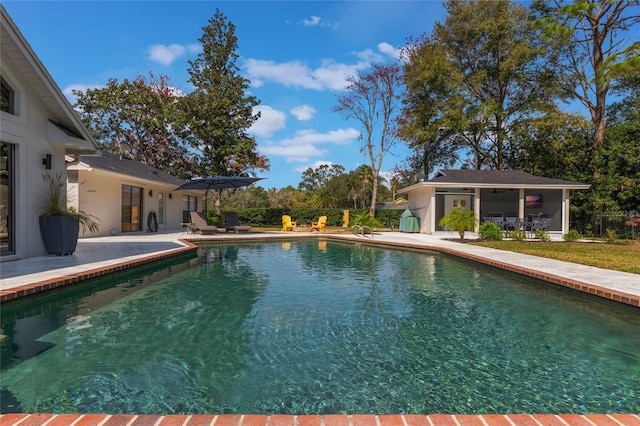 view of pool with an outbuilding and a patio