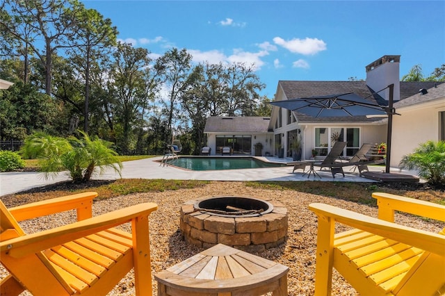 view of swimming pool with a fire pit and a patio area