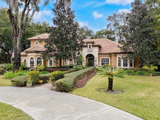 mediterranean / spanish home featuring a front yard