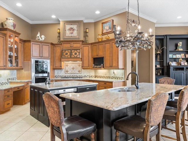 kitchen with sink, a breakfast bar area, light stone counters, a center island with sink, and stainless steel appliances