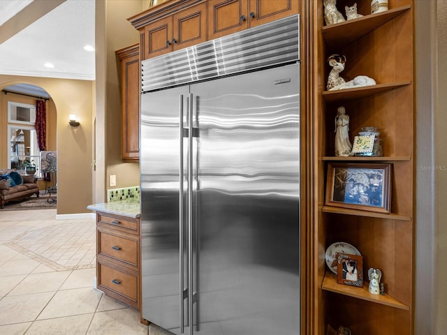 kitchen featuring ornamental molding, built in fridge, built in features, and light tile patterned floors