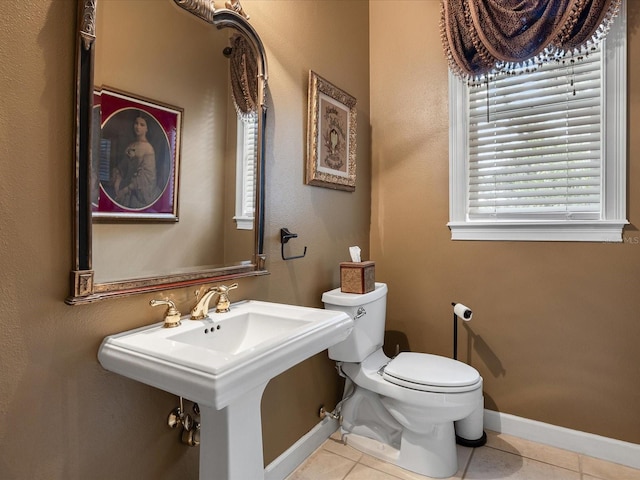 bathroom with sink, toilet, and tile patterned flooring