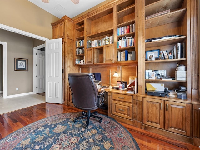 office area featuring dark hardwood / wood-style flooring, built in desk, and ceiling fan