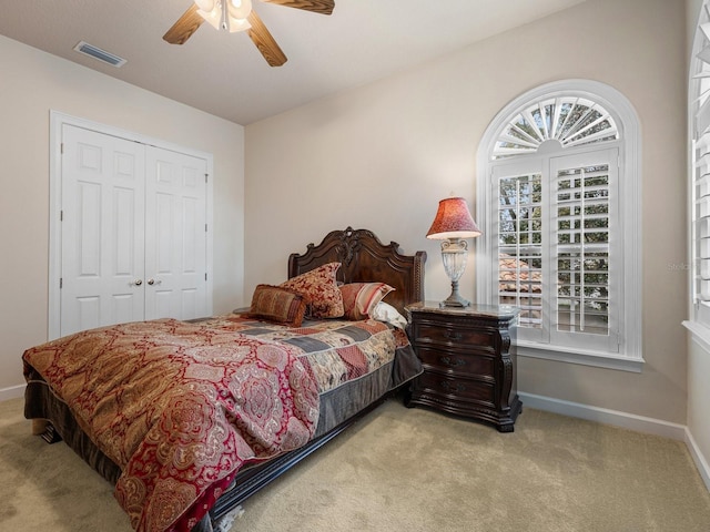 bedroom with light carpet, a closet, and ceiling fan