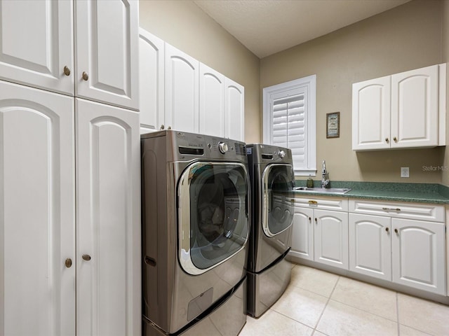 laundry room featuring cabinets, separate washer and dryer, sink, and light tile patterned floors