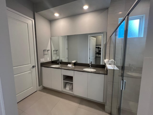 bathroom featuring tile patterned floors, a shower with door, and vanity