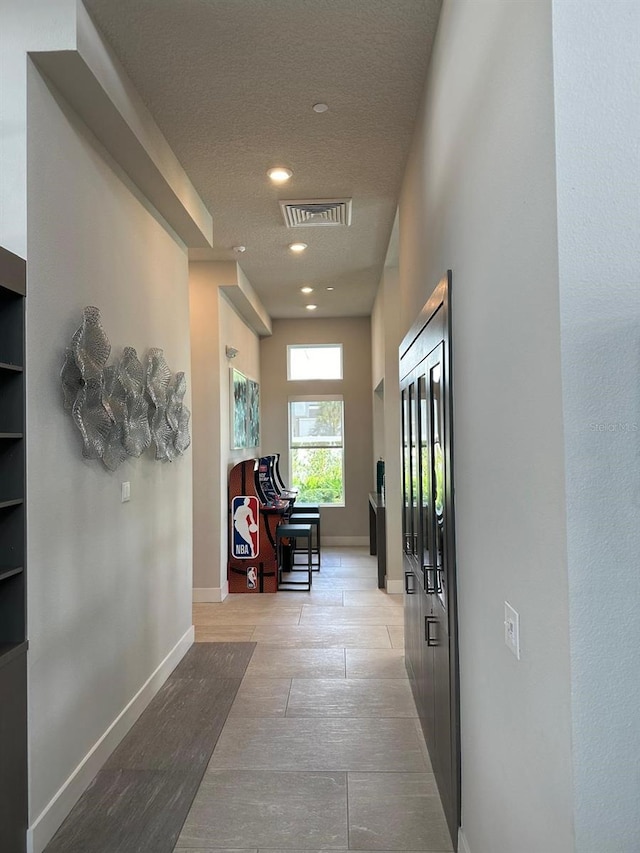 hall featuring a textured ceiling