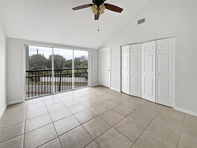 unfurnished bedroom with light tile patterned flooring, high vaulted ceiling, a closet, ceiling fan, and access to exterior