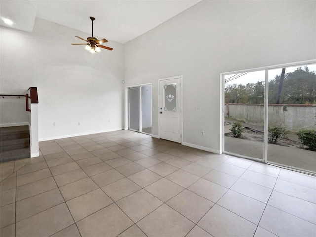 unfurnished living room with light tile patterned flooring, ceiling fan, and high vaulted ceiling