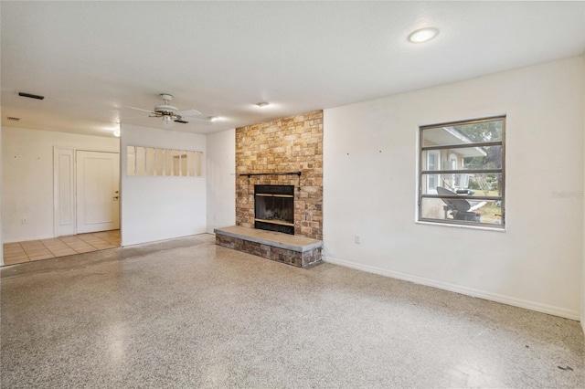 unfurnished living room featuring a large fireplace, a textured ceiling, and ceiling fan