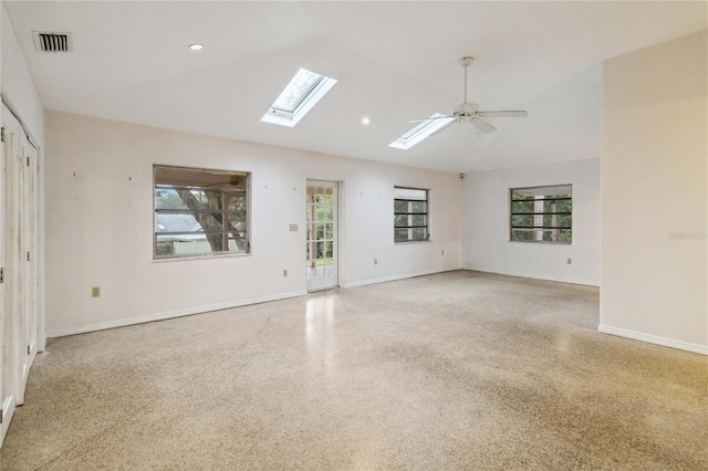 empty room with lofted ceiling with skylight and ceiling fan