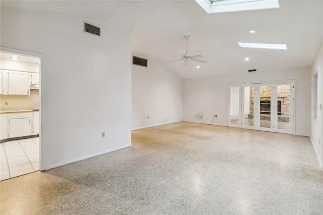 interior space with lofted ceiling with skylight and ceiling fan