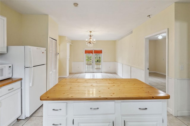 kitchen with butcher block counters, pendant lighting, and white cabinets