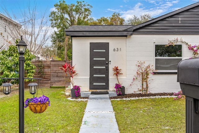 view of exterior entry featuring a yard