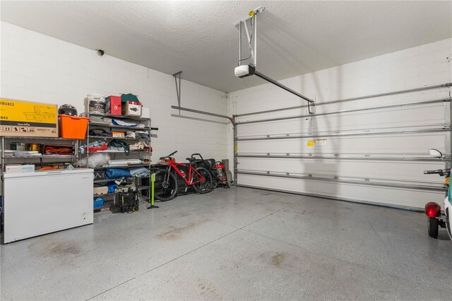 garage featuring a garage door opener and refrigerator