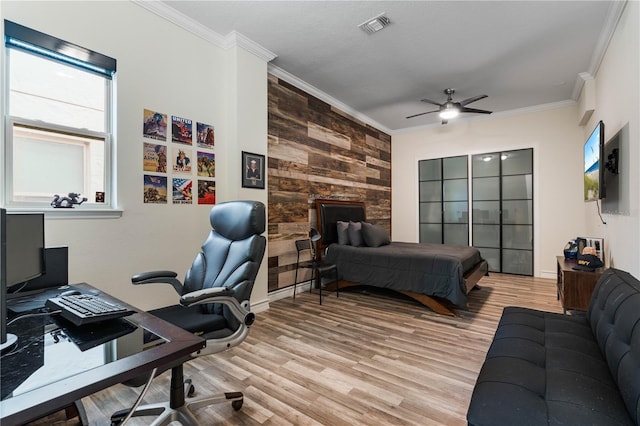 bedroom featuring crown molding, light hardwood / wood-style floors, and ceiling fan