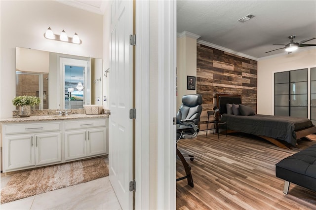 interior space featuring sink, a textured ceiling, ornamental molding, and ceiling fan