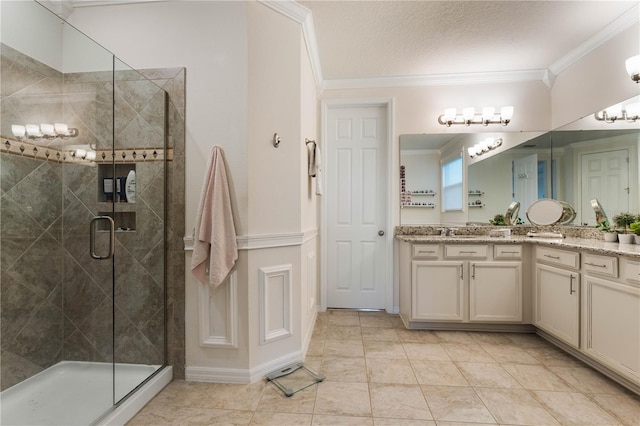 bathroom with vanity, an enclosed shower, and crown molding