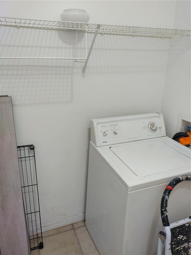 clothes washing area featuring washer / clothes dryer and light tile patterned floors