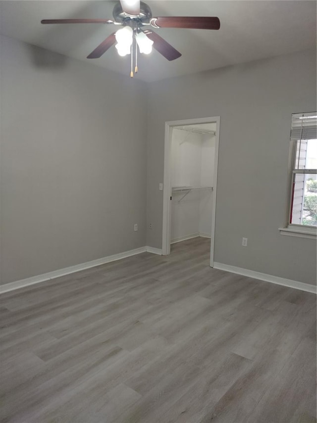 empty room with ceiling fan and light hardwood / wood-style flooring