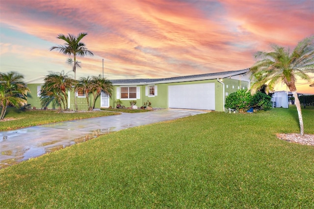 ranch-style house featuring a garage and a lawn