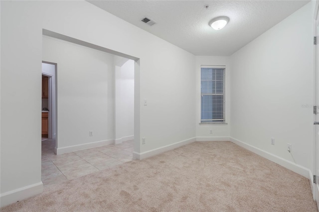 carpeted empty room with a textured ceiling