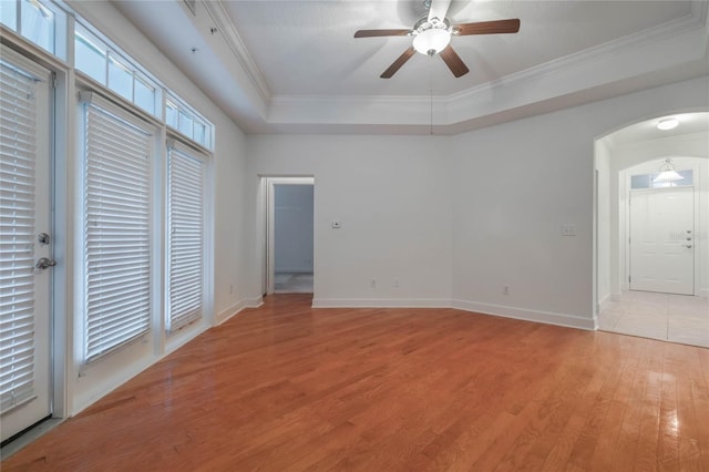 unfurnished bedroom with crown molding, ceiling fan, a raised ceiling, and light hardwood / wood-style flooring